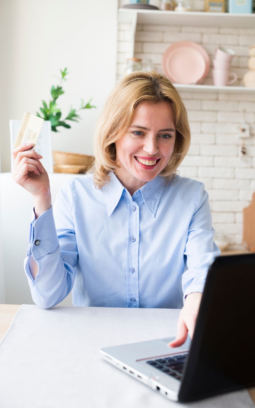 woman holding credit car at computer